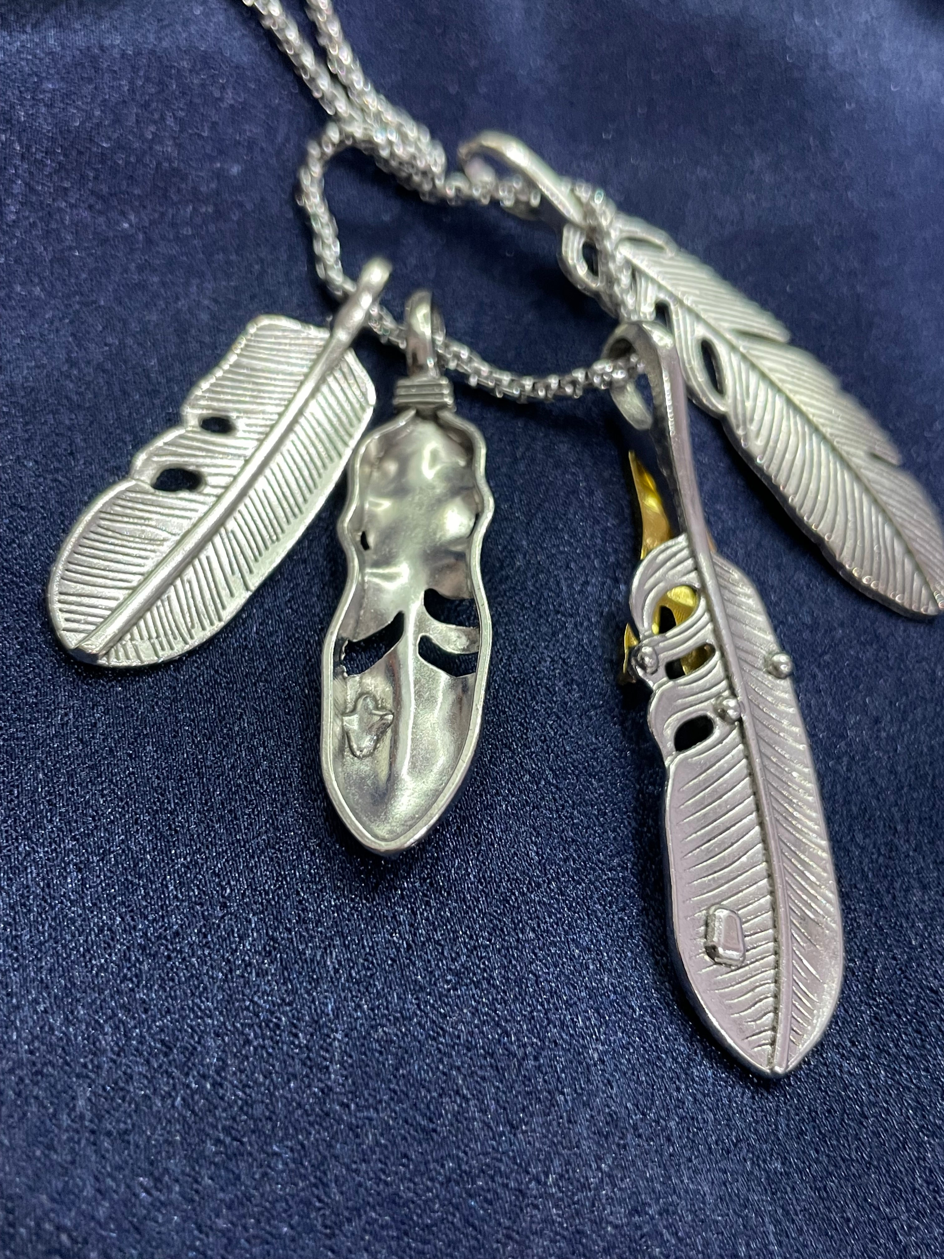 Collana unisex con piume argentate, artiglio dorato e turchese